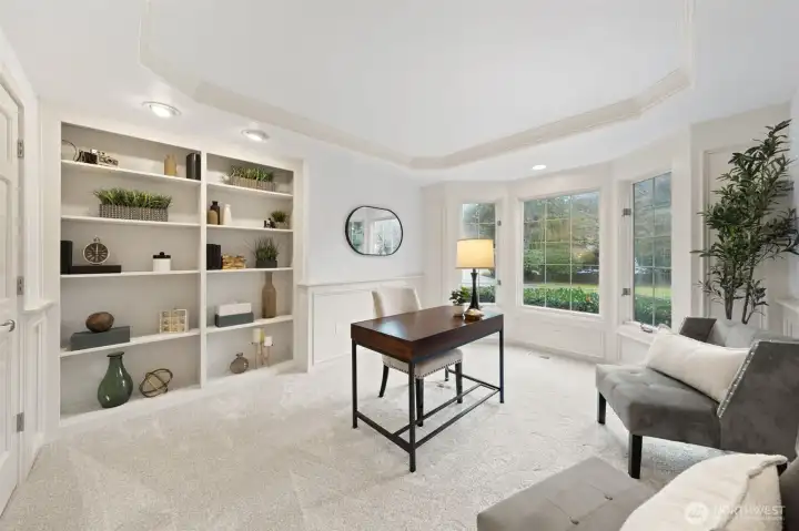 Versatile office/den with built-in shelving, recessed ceiling, and large windows—ideal for a home office, study, or quiet retreat.