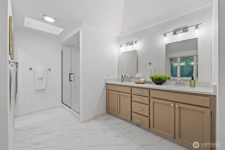 A bright and spacious Primary Bath featuring a dual-sink vanity with generous storage, modern lighting, and elegant finishes. Clean lines and abundant counter space create a spa-like, functional retreat.