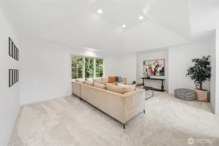 Spacious recreation room highlighted by vaulted ceilings, recessed lighting, new carpeting, and a versatile layout—perfect for a media room, play space, or additional gathering area.