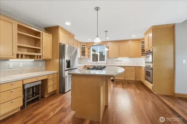 Kitchen with S/S appliances, granite island cooktop, planning desk and a walk-in pantry.