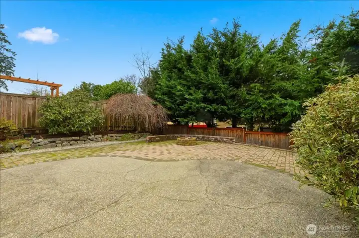 Part of the large back yard with spacious patio and a fire pit.