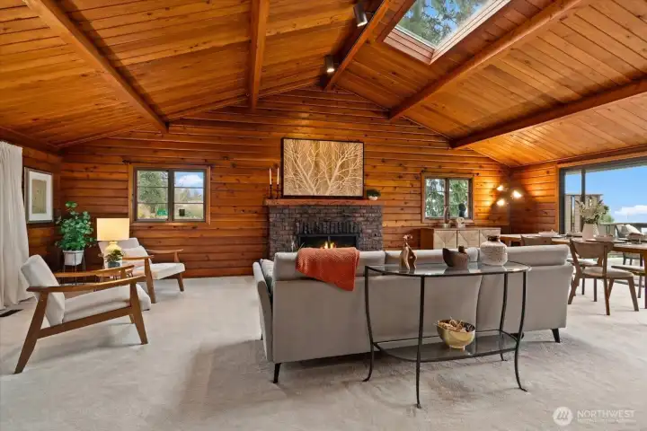 Vaulted ceiling and wood burning fireplace and plush new carpeting, create a warm atmosphere great room