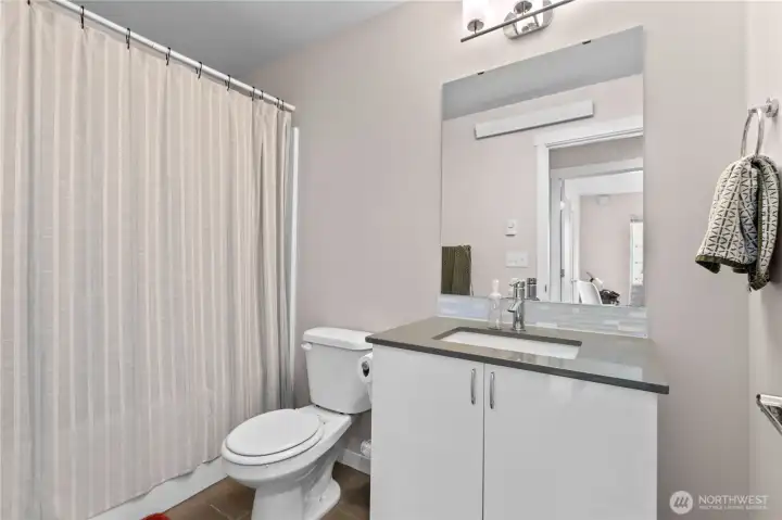 Guest bathroom features a bath/shower.