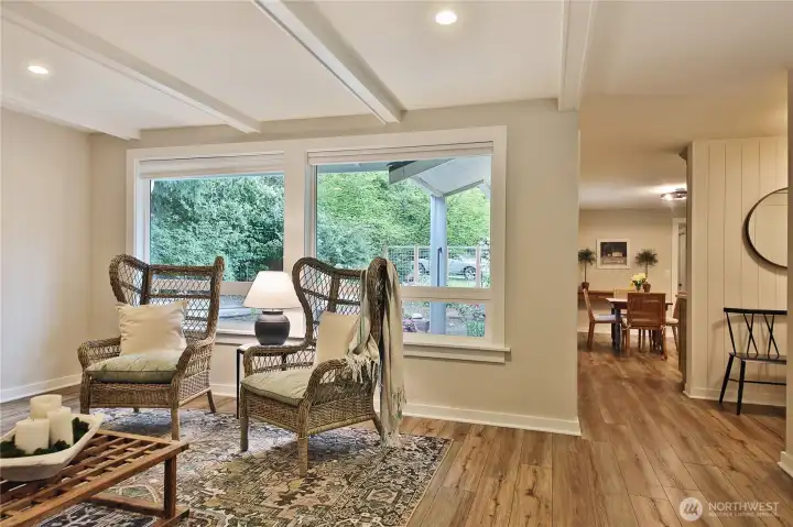 large picture window offer soft northern light, entryway and kitchen beyond.