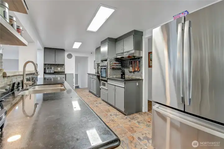Gorgeous kitchen with granite countertops, stainless steel appliances, mosaic tiles, and lots of storage.