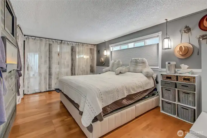 Primary bedroom with a wall of closet space and cozy electric fireplace.