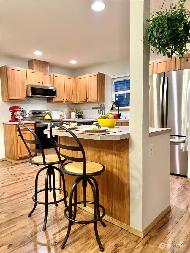 Pull up a stool and keep the cook company at this perfectly-sized kitchen island workspace with breakfast bar. Note the handy outlet on the end to plug your laptop or phone charger into!