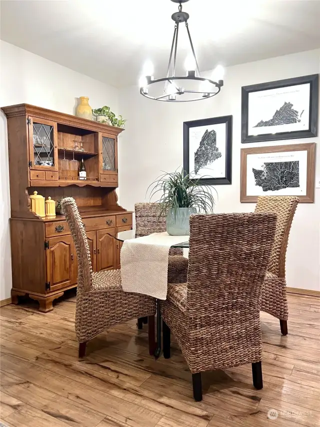 The dining room features Edison style bulb chandelier and the gorgeous wide-plank hardwood laminate flooring found throughout the main floor living areas and kitchen.