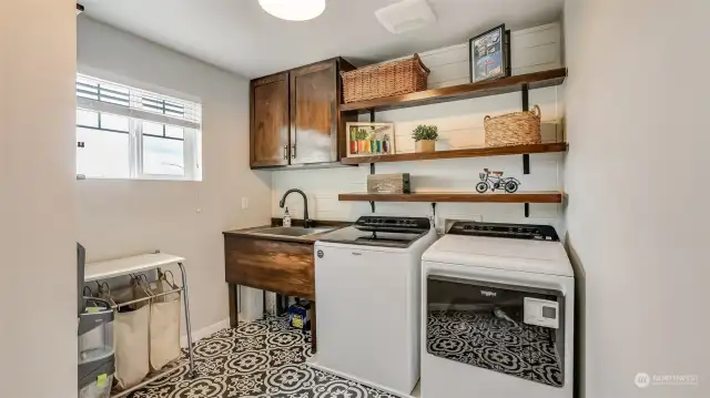 Large laundry room on the second floor with utility sink.
