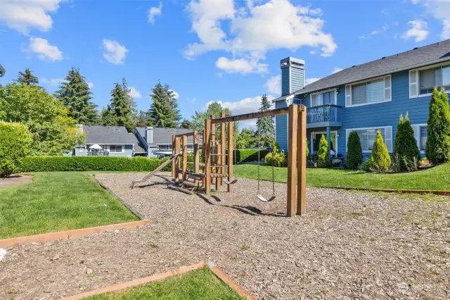Just steps from your building is a serene grassy area with a playground.