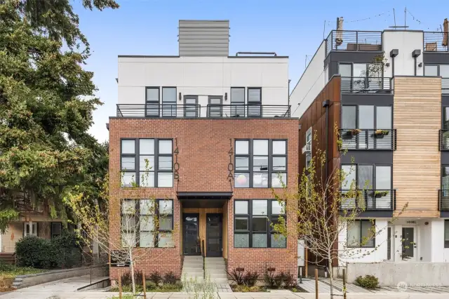 Step into elegance with a grand entryway framed by clean architecture and expansive windows.