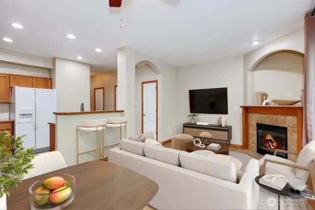 Digitally staged living room and view of kitchen.