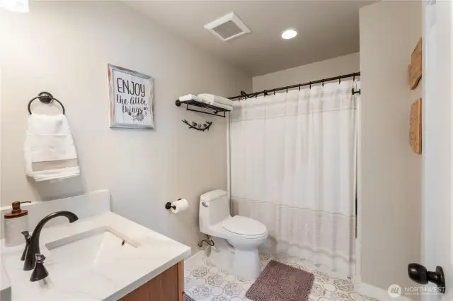 Quartz vanity and custom tile floor.