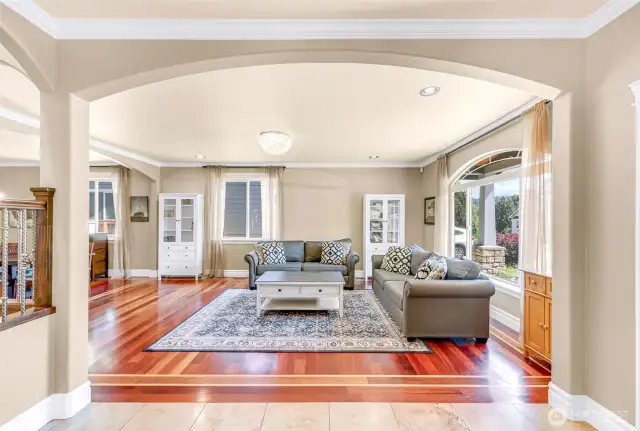 Curved archways, engineered hardwood and travertine tile floors