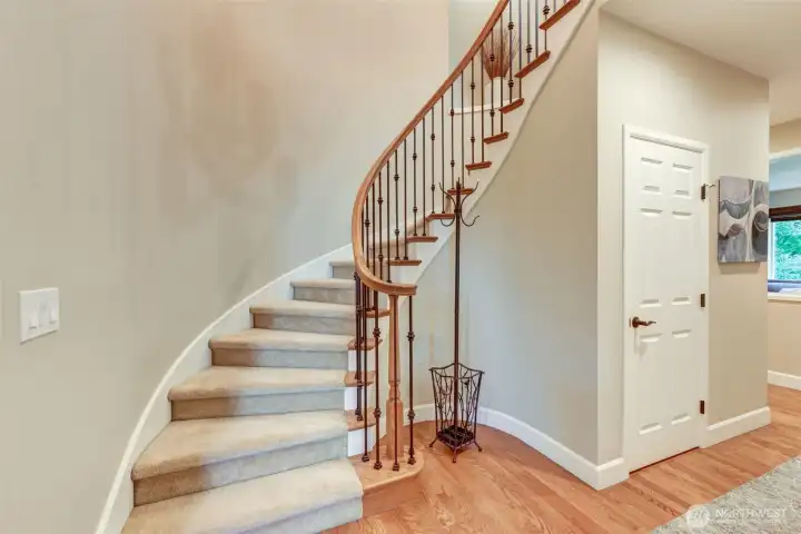 “Statement spiral staircase with wrought-iron banister leads to a bright, sky-lit landing and the home’s thoughtfully designed upstairs layout.”