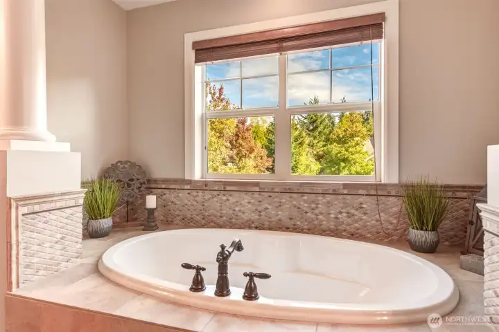 “Soaking tub with east-facing windows—peaceful sunrises create a serene start to your day.”