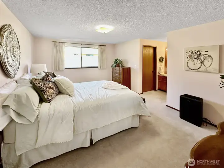 Primary bedroom with walk-in closet and 3/4 bath offers ample room for night stands and dressers.