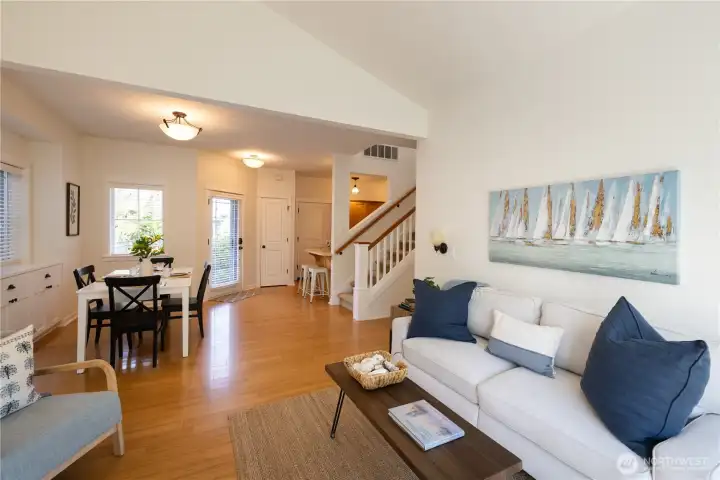 Vaulted living room with adjacent dining room with nice built-ins, access to the main floor primary bedroom suite, the kitchen, a 1/2 bath with washer and dryer, the 2 car garage, and stairway leading to the upper floor and all it has to offer.