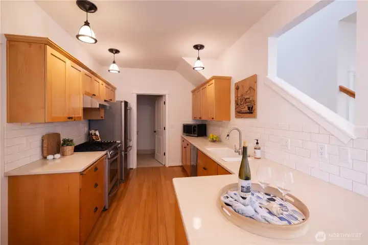 Great kitchen with all stainless appliances, nice wood cabinets, lots of counter space. A 1/2 bath with sink, and a  washer and a dryer with more cabinets above these appliances provide room for cleaning supplies and or additional pantry space.