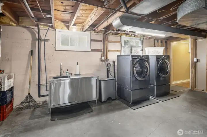 Downstairs laundry room with sink and stairs to back patio