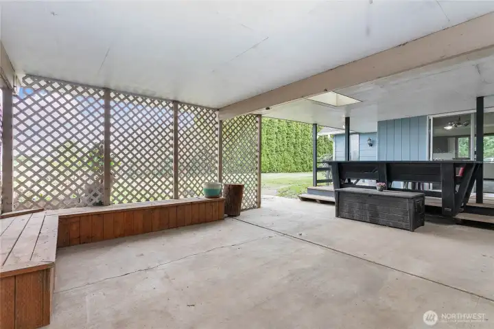 Covered patio space with bench off the sliding door.