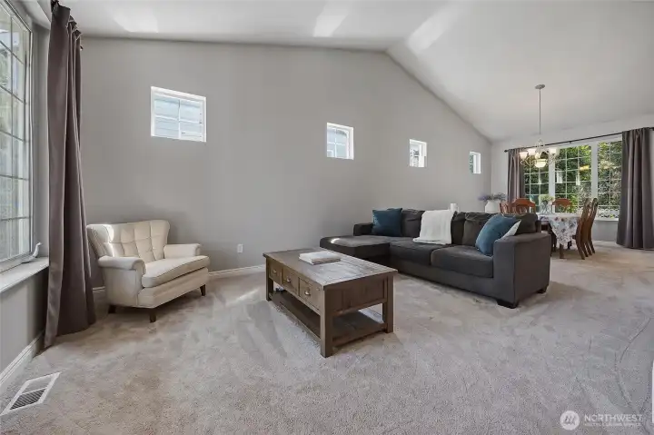 A spacious living and dining area is located to the left of the entry, complete with vaulted ceilings