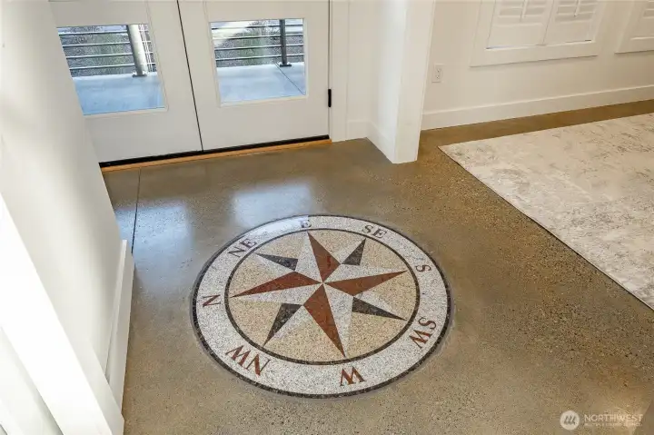 Entry foyer with custom granite compass rose inset into the finished concrete floor. Entry foyer with custom granite compass rose inset into the finished concrete floor.