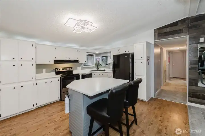 Generous kitchen with newer countertops and appliances. New high end light fixtures throughout elevate the spaces. Newer laminate wood flooring in the kitchen give a charming farmhouse vibe. Generous kitchen with newer countertops and appliances. New high end light fixtures throughout elevate the spaces. Newer laminate wood flooring in the kitchen give a charming farmhouse vibe.