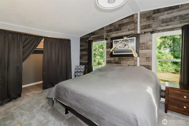 Large Primary Bedroom includes oversized walk-in closet, vaulted ceilings, two large windows, new plush carpet, and new modern lighting fixture. Large Primary Bedroom includes oversized walk-in closet, vaulted ceilings, two large windows, new plush carpet, and new modern lighting fixture.