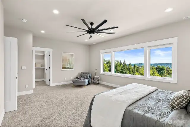 Welcome to the primary bedroom, a serene retreat designed for both luxury and comfort. Bask in the abundant natural light streaming through the expansive windows, which frame breathtaking views of Dyes Inlet and the majestic Cascade Mountains.