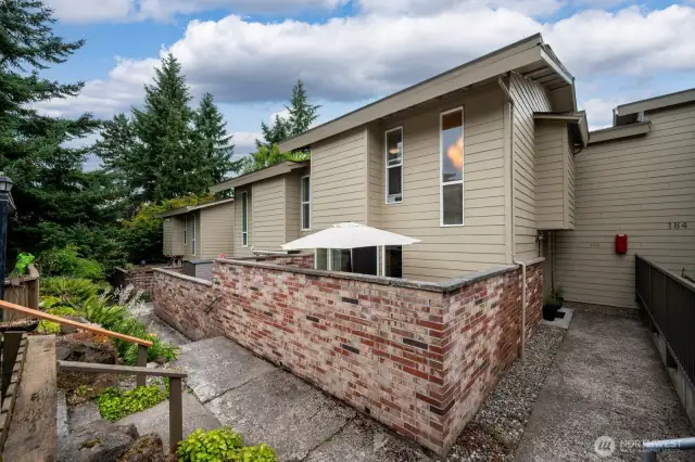 Front of home with brick enclosed patio for privacy and outdoor dining and enjoyment.
