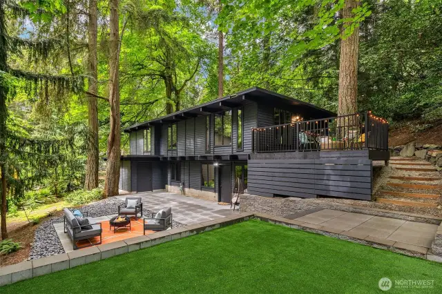 Mid-century inspired design on a wooded lot with patio, turf yard and deck