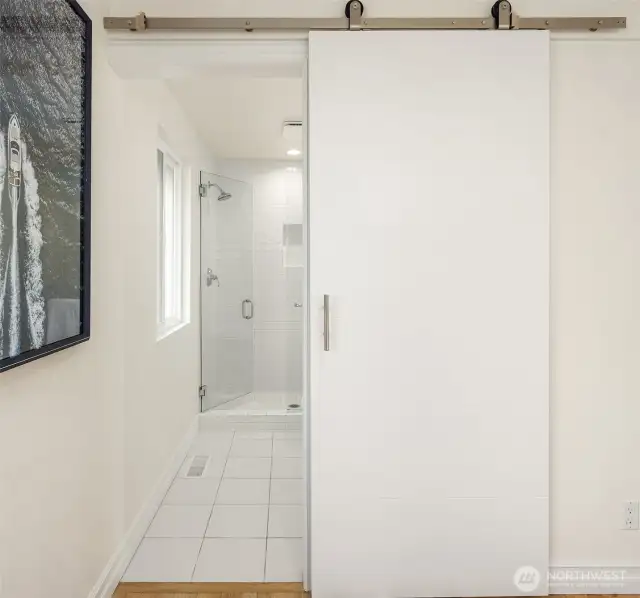 New farm door leads to primary bathroom.