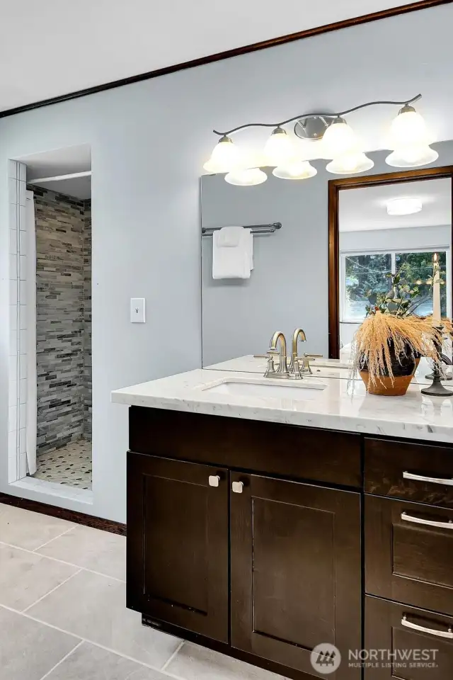 Double sinks, marble countertops and a beautifully tiled shower complete the primary suite. Remodeled in 2021.
