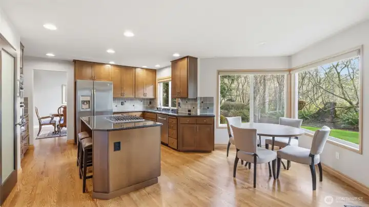 The large bank of windows allows the eating nook to see and feel like you are in the private and beautiful backyard.