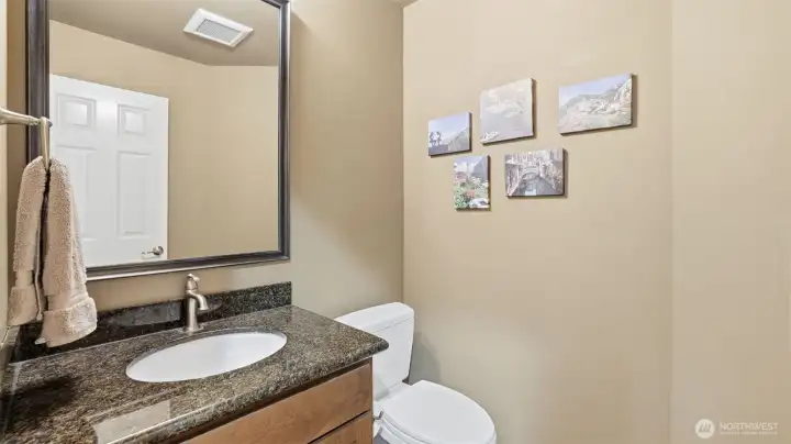 The powder room has been updated with custom colors and a granite counter top.