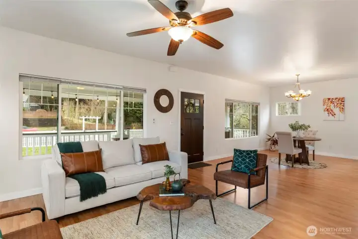 Front room with large windows and ceiling fan.