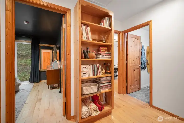 As you leave the main part of the home, you'll see the built-in custom cabinetry for additional storage (another storage area just across the bookcase--not int the picture) plus access to both bedrooms, a large utility room, and a bathroom.