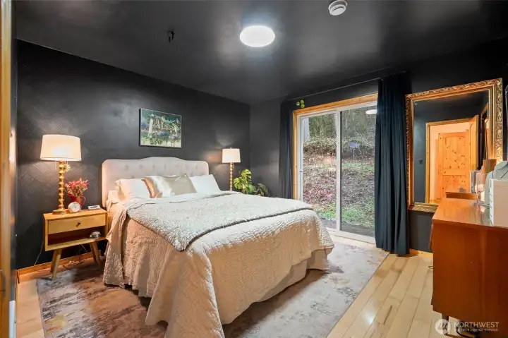 The primary bedroom has its own sliding glass door to the outside. Enjoy nature, listen to the creek/waterfall, or add your own patio area if you want!