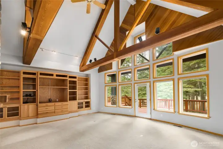 Sunken living room with gorgeous exposed beams, vaulted ceilings & a built-in entertainment center.