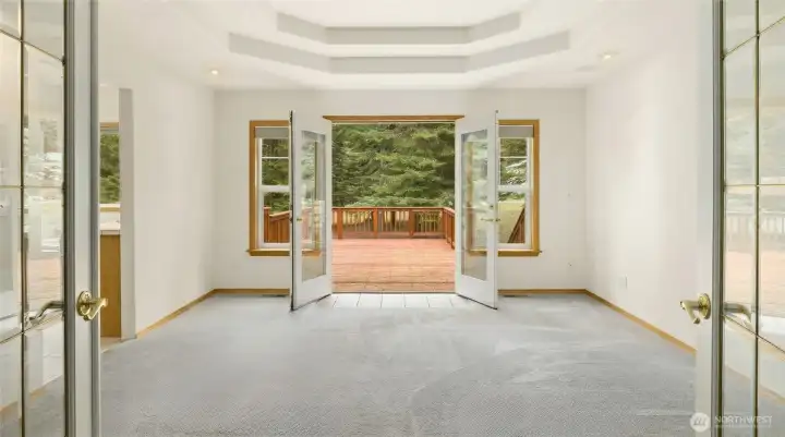 Primary Suite welcomes you with French doors & coffered ceilings. The bedroom has access directly to the huge back deck!