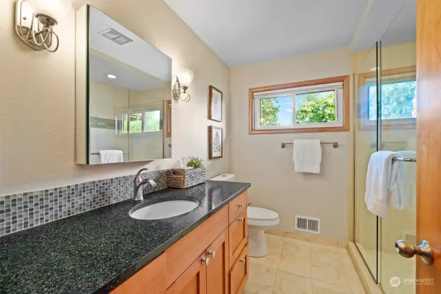 Fully updated main-level bath features radiant floor heat and glass walk-in shower