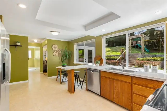 Large, open kitchen with wall of windows that open to the backyard. Making communication between inside & out, seemless.