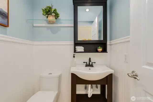 Charming half bathroom on the main level with wainscoting.