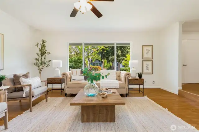 Bright living room with a large front window that floods the room with natural light.