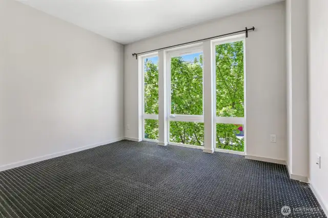 Floor to ceiling windows overlooking 15th Avenue NW in the Primary Bedroom