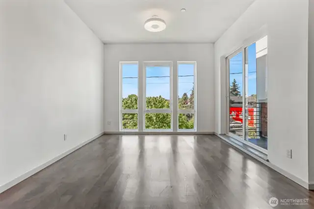 Living room drenched in natural light from windows and door to BBQ patio.