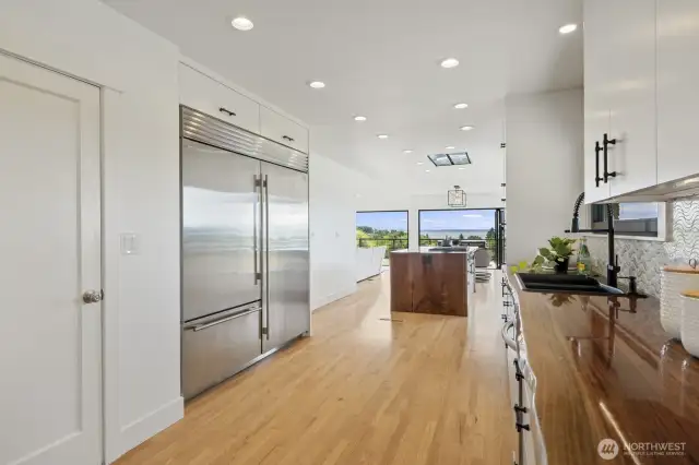 Live edge walnut counters, walk-in pantry and 72" Sub-Zero refrigerator in the kitchen.