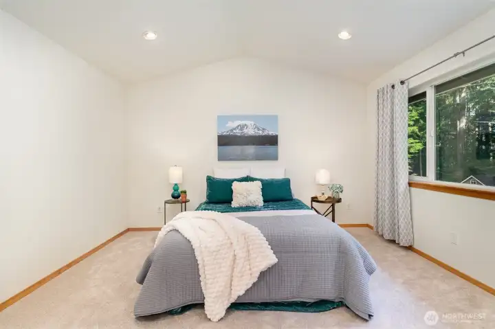 The luxurious Primary Suite features a vaulted ceiling, 5-piece bath, walk-in closet & a soaking tub.