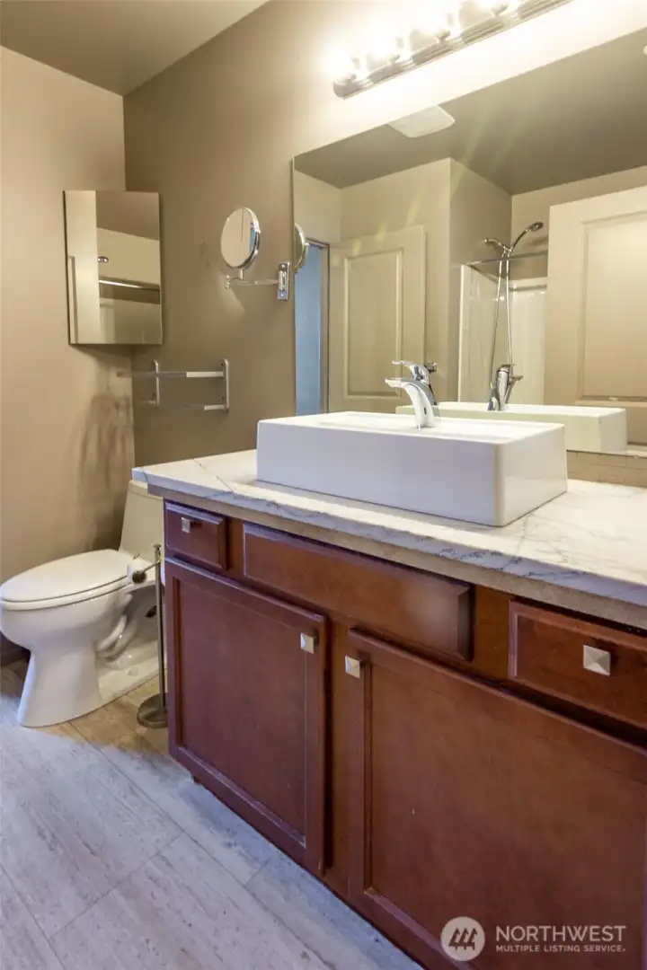 The ensuite bath is updated with a beautiful sink and handy vanity mirror.